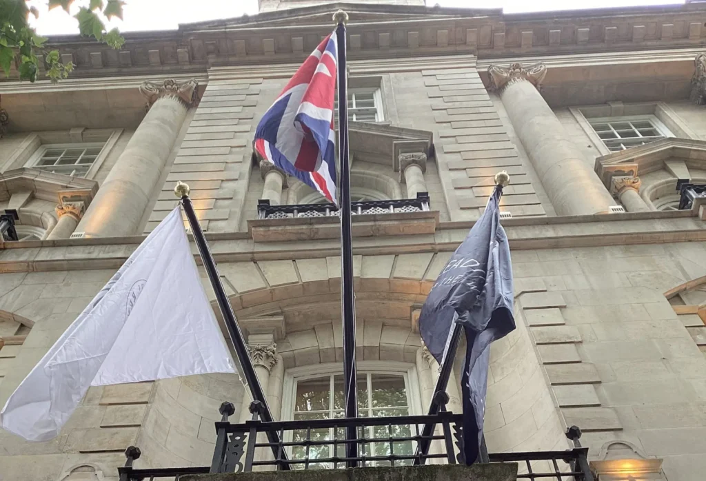 Triple mounted flags at the front of the L'Oscar hotel following protocols of the Union Flag in the senior position