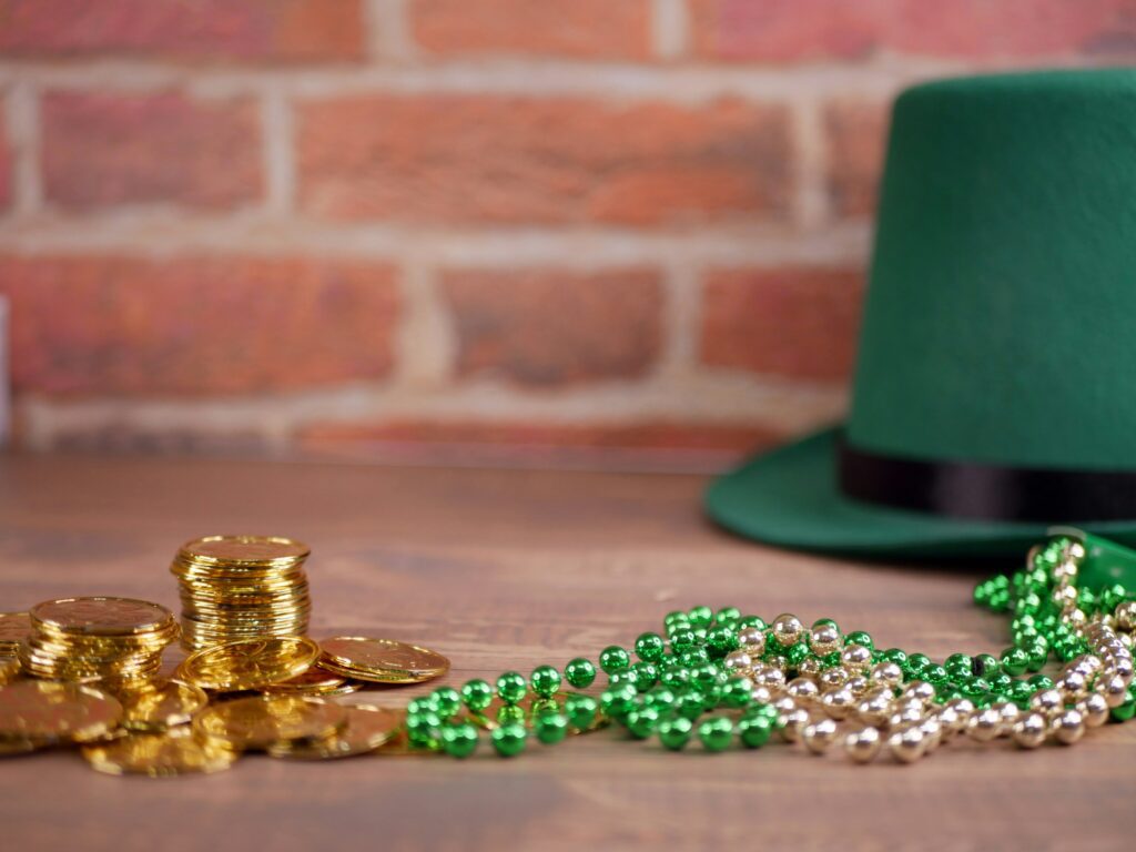 St Patricks Day - gold coins and green hat on table with brick wall background